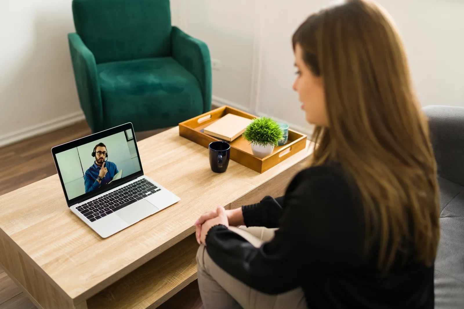 Una mujer conversa por videollamada desde casa, explorando su mente en crecimiento en un ambiente acogedor.